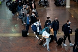 Health experts urge travelers to mask, vaccinate and isolate if ill